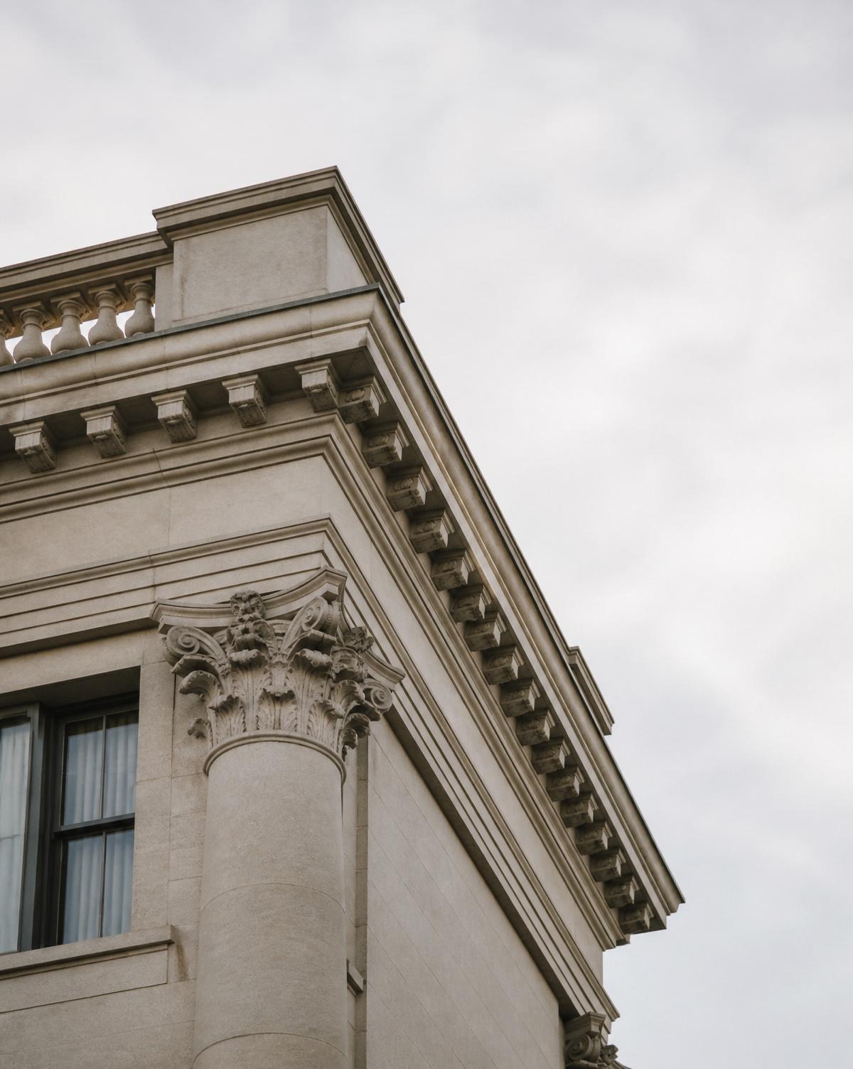 Limestone cornice against soft sky